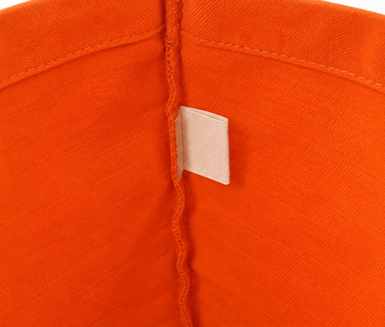 Økologisk bomullsnett, 30 × 35 cm, nærbilde av etiketten på innsiden – oransje